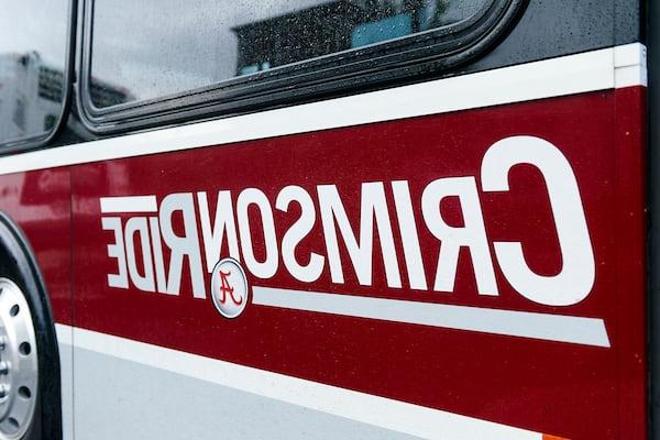 A side of a Crimson Ride bus displays the Crimson Ride logo